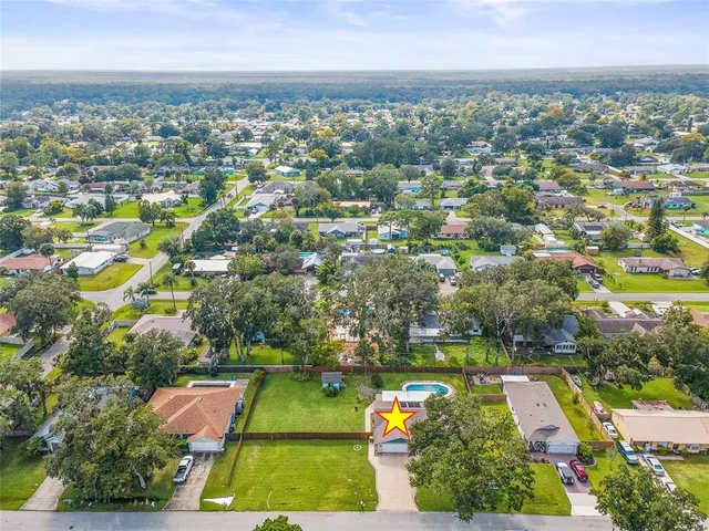 an aerial view of residential houses with outdoor space and trees