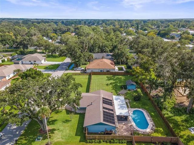 a aerial view of a house with a garden and lake view