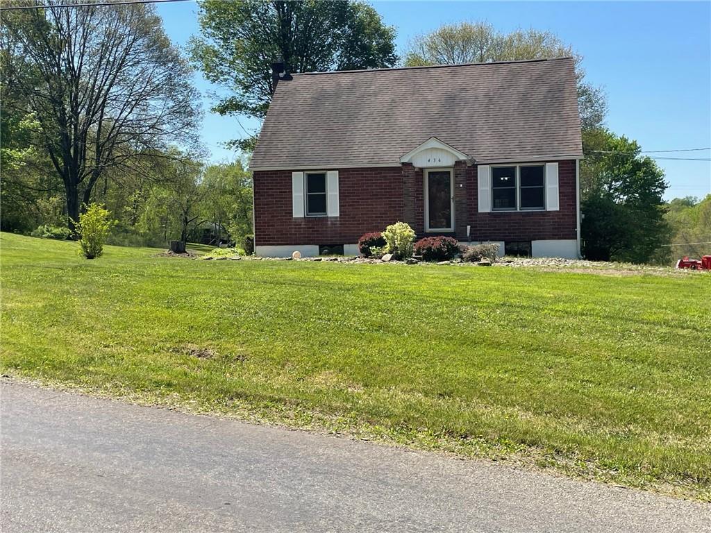 a front view of a house with yard and trees