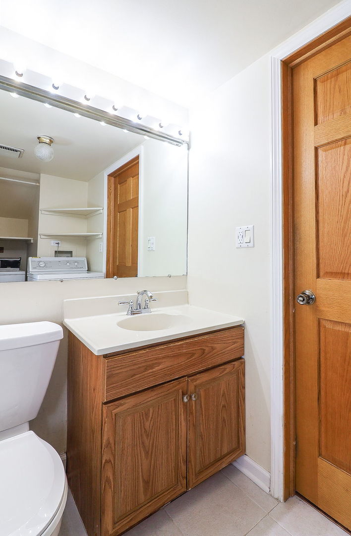 1482 Timber Trail, Unit B Wheaton, IL 60189 - Photo 17 of 20 a bathroom with a toilet a sink a mirror and vanity