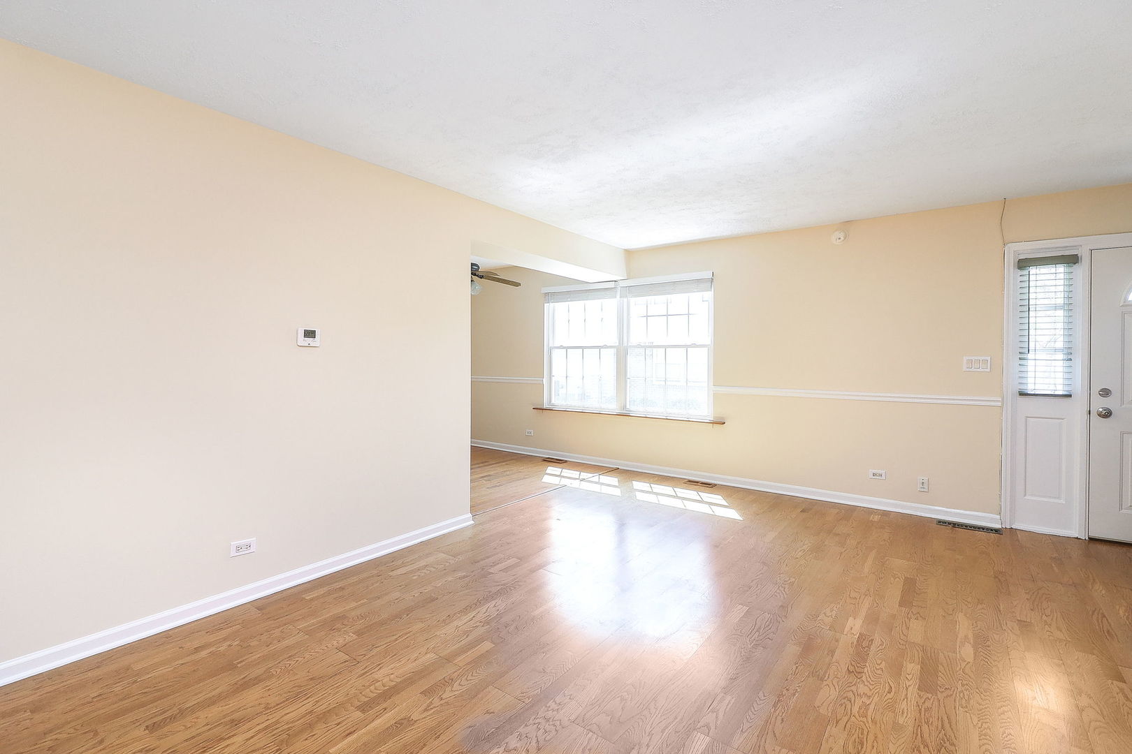 1482 Timber Trail, Unit B Wheaton, IL 60189 - Photo 5 of 20 an empty room with wooden floor and windows