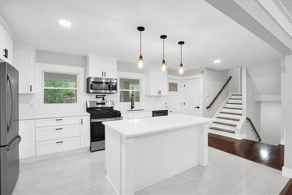 a kitchen with white cabinets and appliances