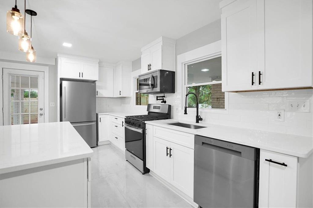 2271 Cresta Drive Decatur, GA 30032 - Photo 10 of 47 a kitchen with a sink a stove a refrigerator and white cabinets