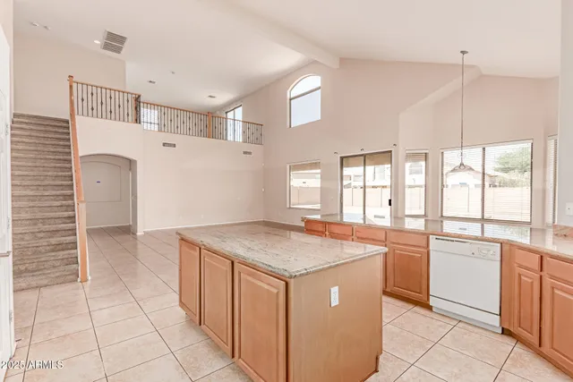 a kitchen with a stove a sink a refrigerator and white cabinets with wooden floor