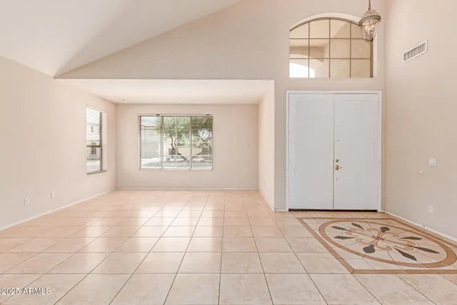 an empty room with windows and ceiling fan
