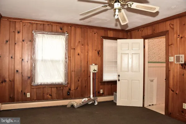a view of a bedroom with wooden floor and windows