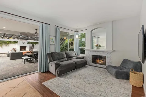 a kitchen with stainless steel appliances kitchen island a table chairs in it and wooden floors