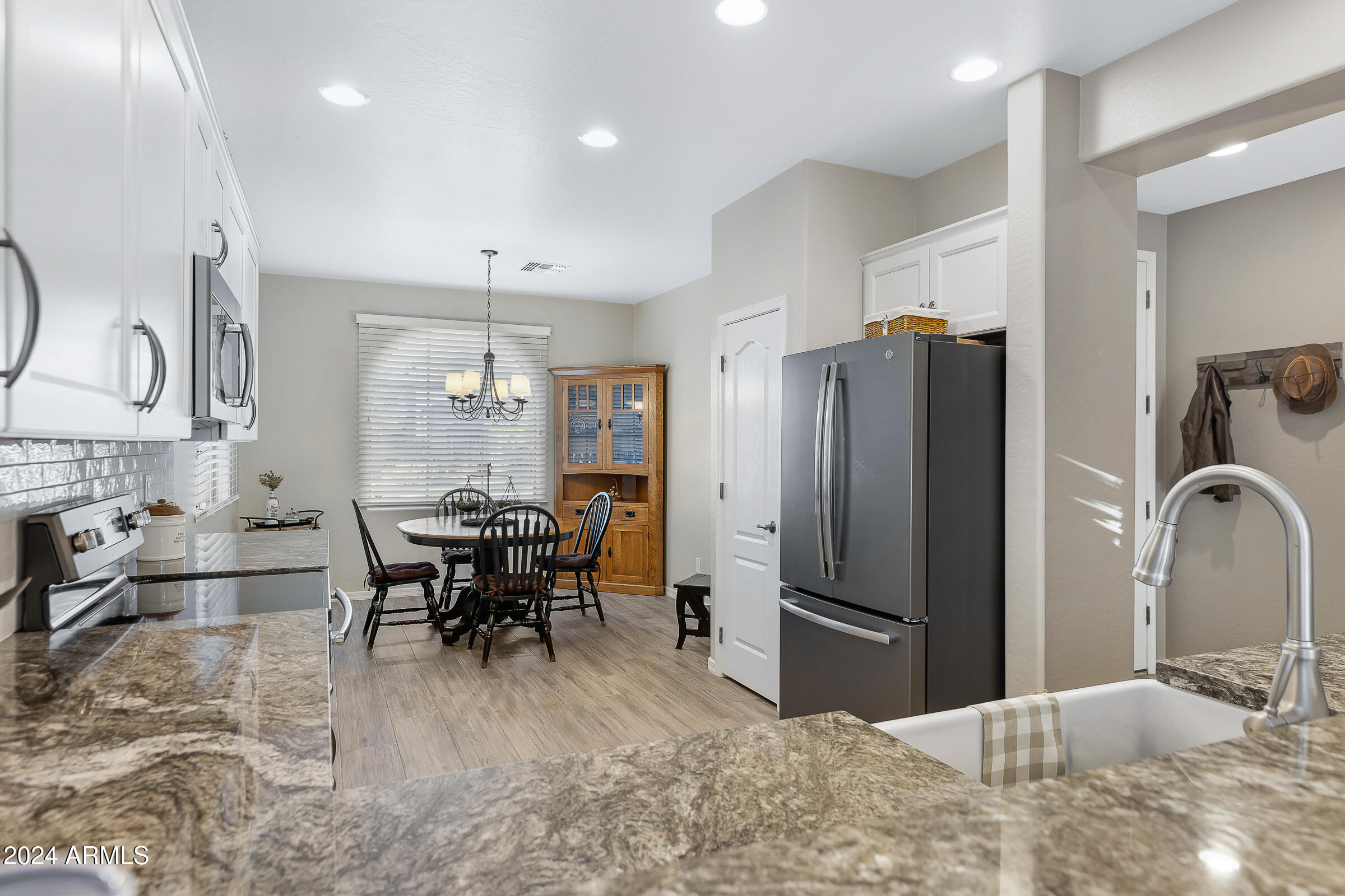 4741 East Timberline Road Gilbert, AZ 85297 - Photo 11 of 44 a kitchen with stainless steel appliances kitchen island granite countertop a refrigerator and a sink