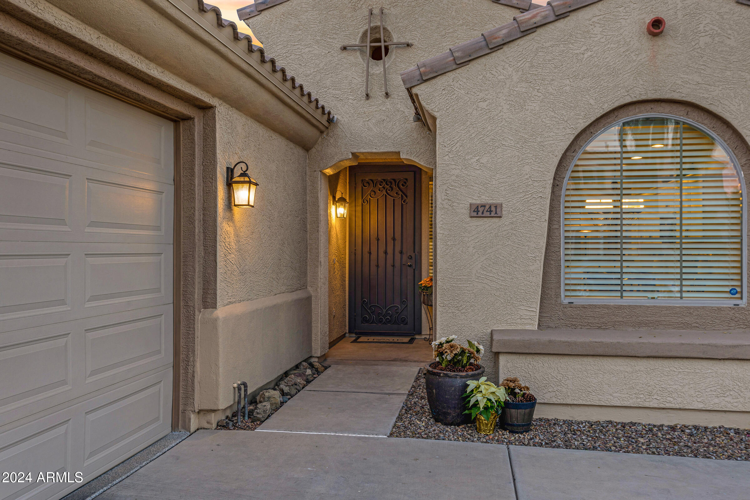 4741 East Timberline Road Gilbert, AZ 85297 - Photo 4 of 44 a front view of a house with a potted plant and garage