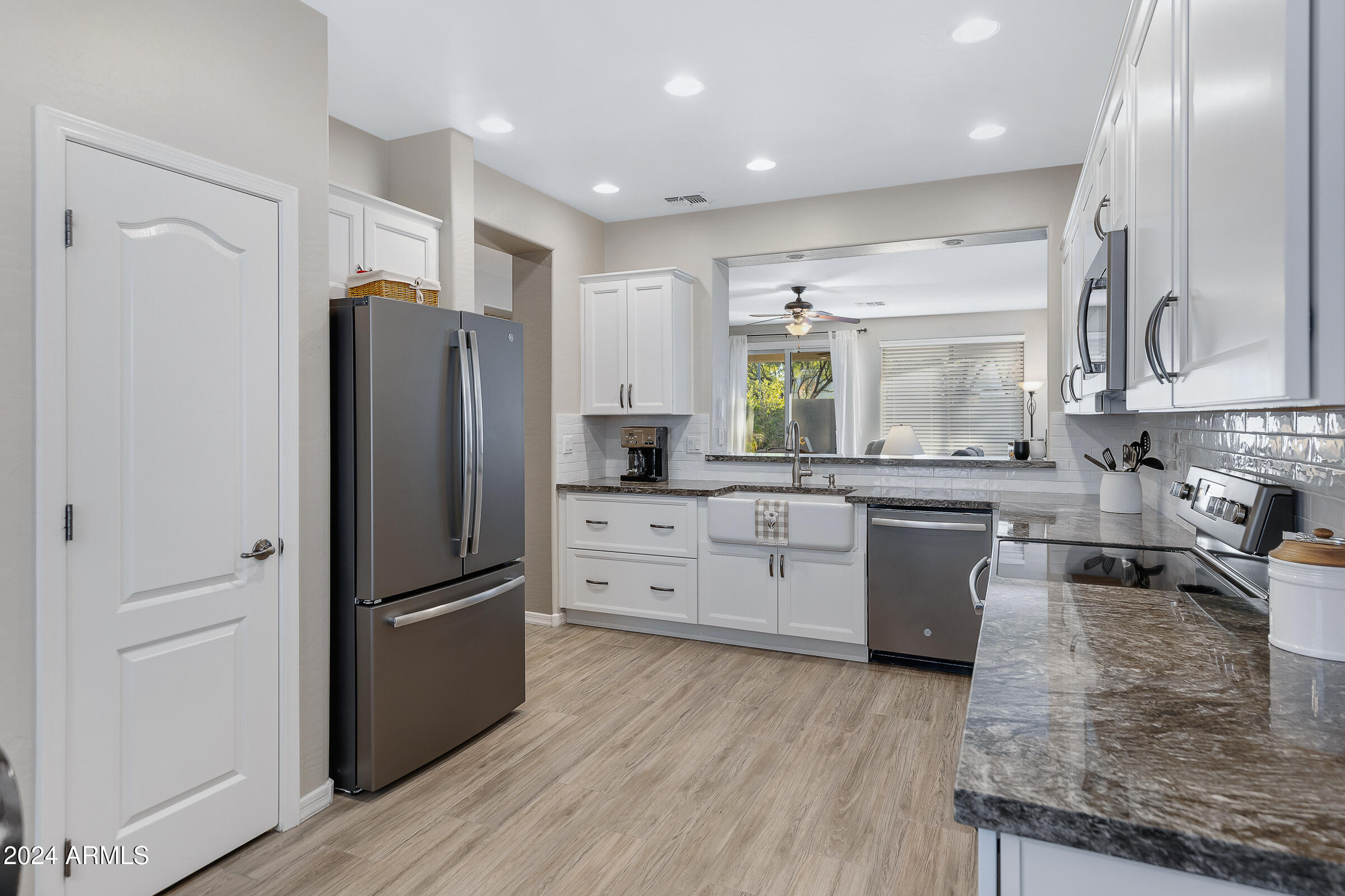 4741 East Timberline Road Gilbert, AZ 85297 - Photo 7 of 44 a kitchen with stainless steel appliances granite countertop a refrigerator sink and cabinets