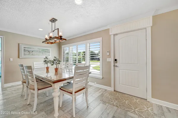 a room with chandelier fan and wooden floor