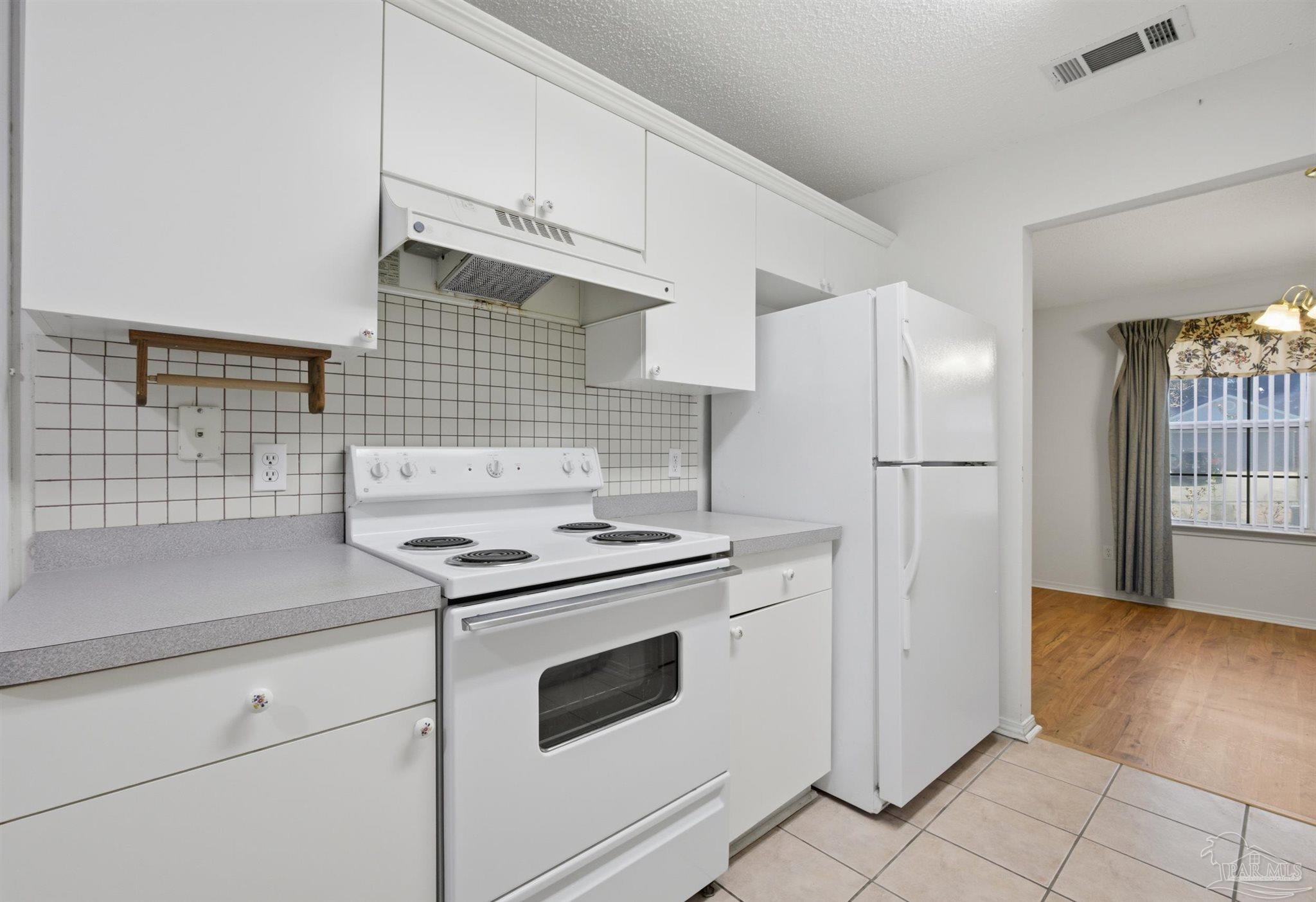 4327 Chantilly Way Milton, FL 32583 - Photo 6 of 32 a kitchen with granite countertop white cabinets and white appliances