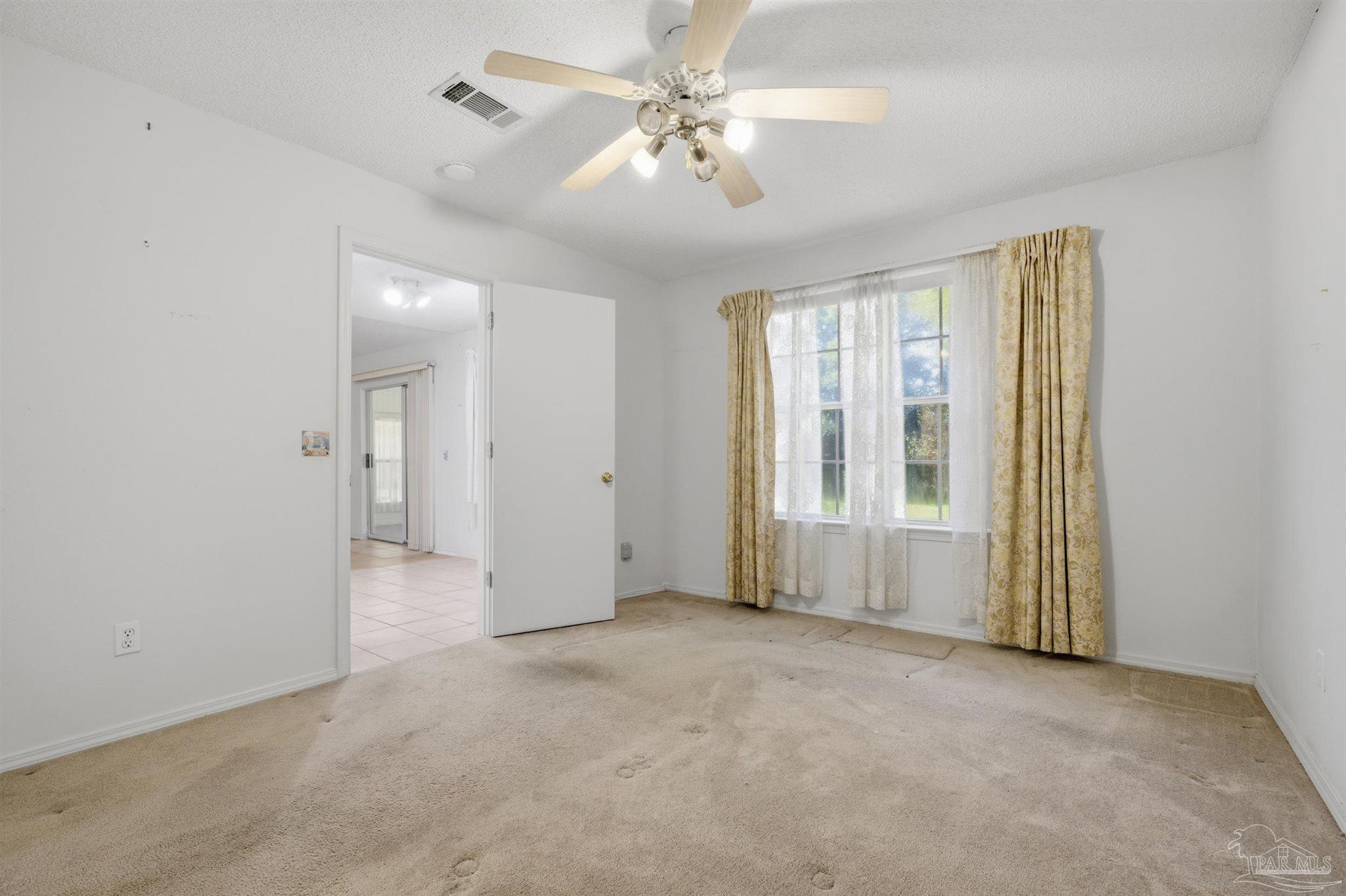 4327 Chantilly Way Milton, FL 32583 - Photo 10 of 32 an empty room with chandelier fan and windows