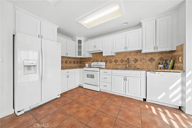 a spacious bathroom with a granite countertop sink a toilet a mirror and shower