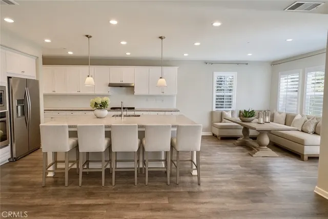 a living room with stainless steel appliances kitchen island granite countertop furniture and a wooden floor