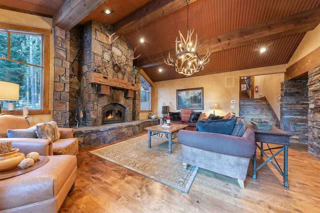 a living room with furniture a fireplace and a chandelier