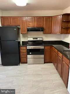 a kitchen with wooden cabinets and a stove top oven