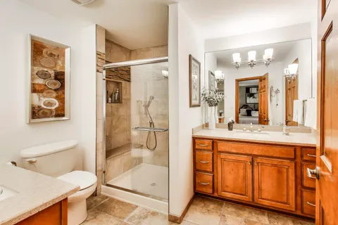 a bathroom with a granite countertop sink mirror and a bathtub