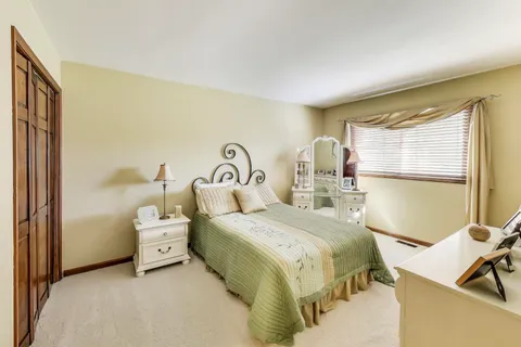 a bedroom with a bed and large window