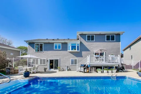a view of a patio with a table chairs and a swimming pool