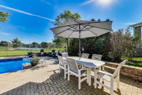 a view of a patio with couches potted plants and a big yard