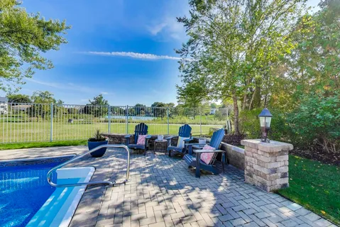a view of swimming pool with outdoor seating and yard in the back