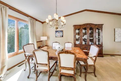 a dining room with furniture a chandelier and window
