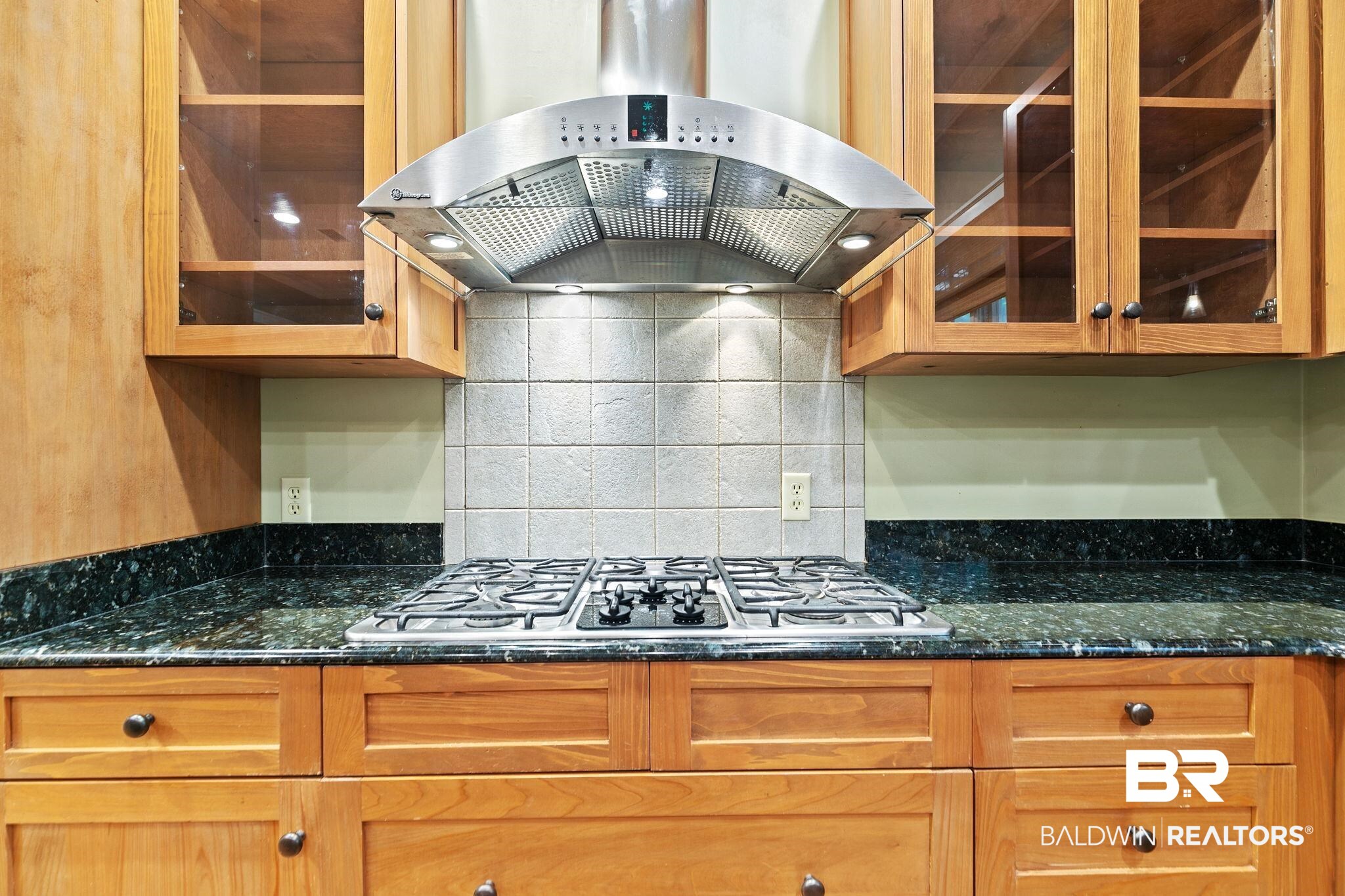 202 Beall Lane Daphne, AL 36526 - Photo 16 of 46 Kitchen featuring dark stone countertops, tasteful backsplash, stainless steel gas stovetop, and wall chimney exhaust hood