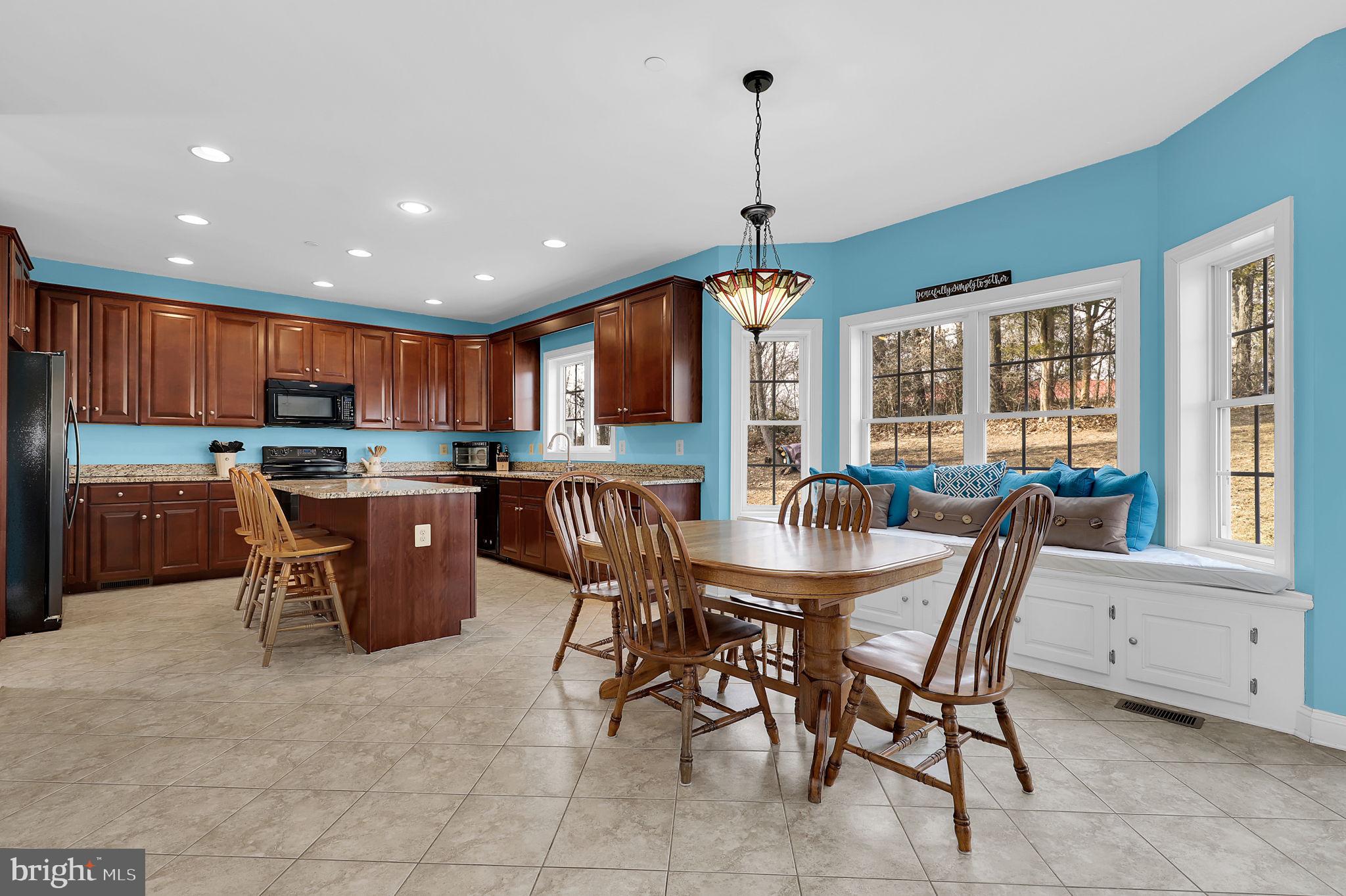 6024 Old Bohn Road Mount Airy, MD 21771 - Photo 17 of 46 a kitchen with stainless steel appliances granite countertop a stove top oven a sink a dining table and chairs