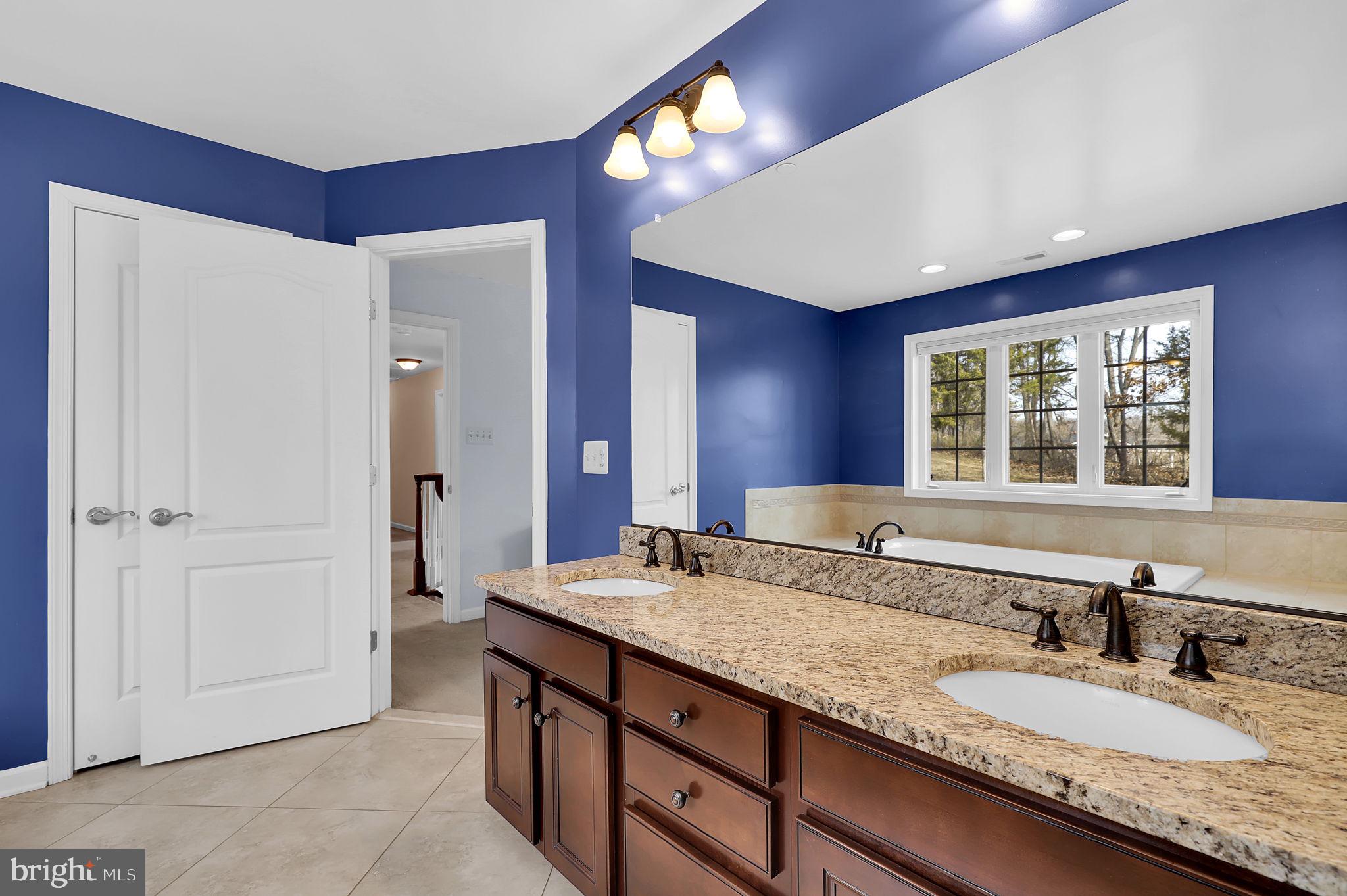 6024 Old Bohn Road Mount Airy, MD 21771 - Photo 28 of 46 a bathroom with a granite countertop double vanity sink a mirror and a bathtub