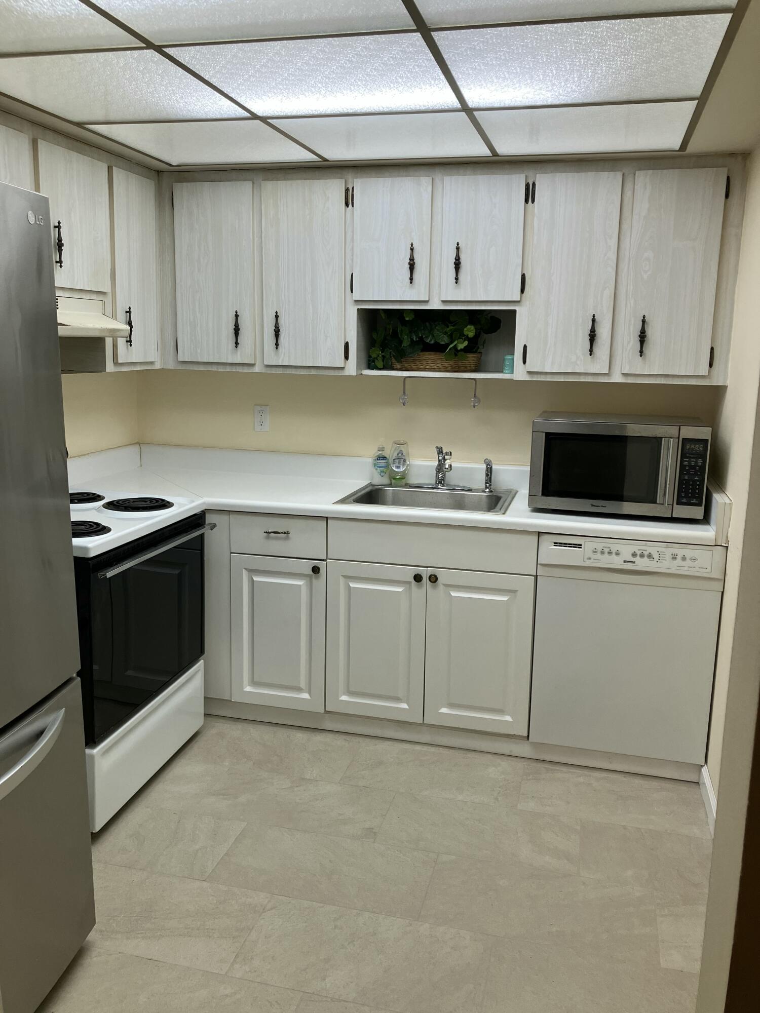 950 South Kanner Highway, Unit C2 Stuart, FL 34994 - Photo 6 of 14 a kitchen with stainless steel appliances granite countertop a stove a sink and white cabinets