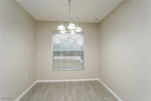 a view of a room with wooden floor exposed radiator and a window
