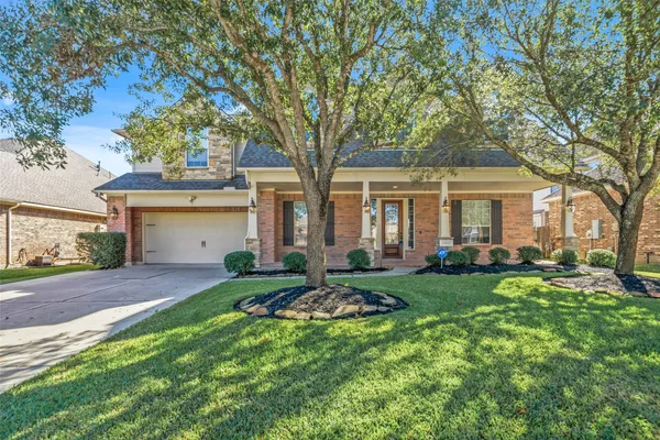 a view of a house with backyard and a tree