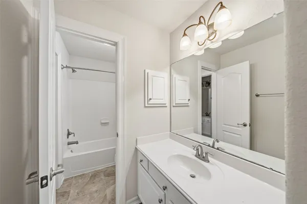 a bathroom with a bathtub a sink and a mirror