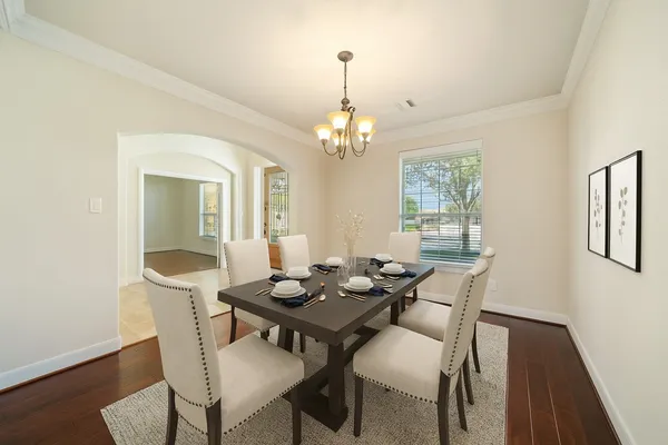 a dining room with furniture a chandelier and wooden floor