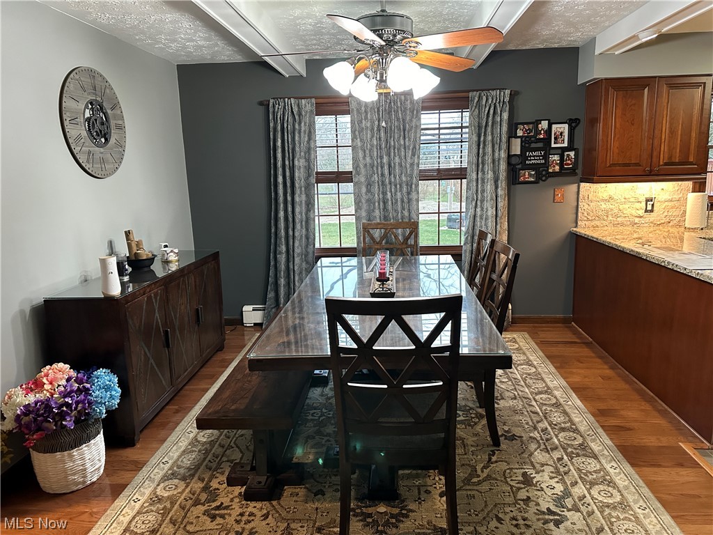 13055 Unity Road New Springfield, OH 44443 - Photo 15 of 49 Dining room featuring dark hardwood / wood-style flooring, a baseboard radiator, a textured ceiling, and ceiling fan