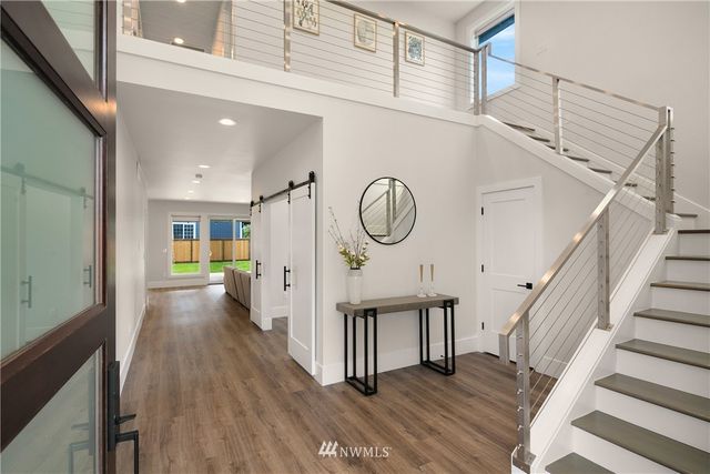 a view of a hallway with wooden floor and staircase
