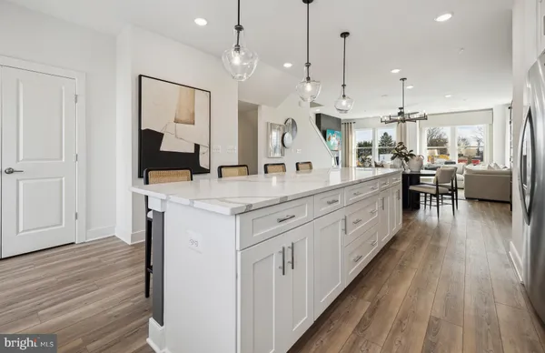 a large white kitchen with lots of counter space wooden floor and appliances