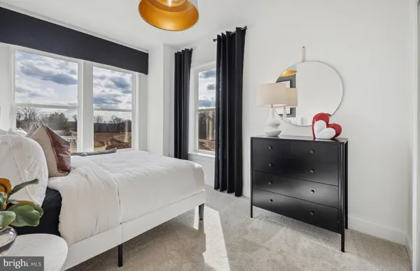 a bedroom with a bed and dresser with mirror