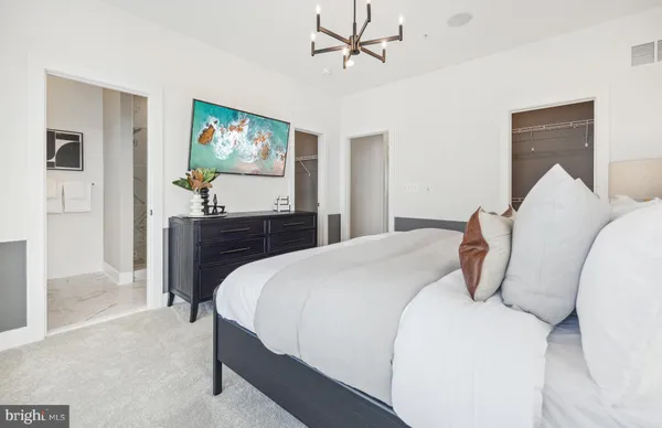 a bedroom with a bed and painting on the wall