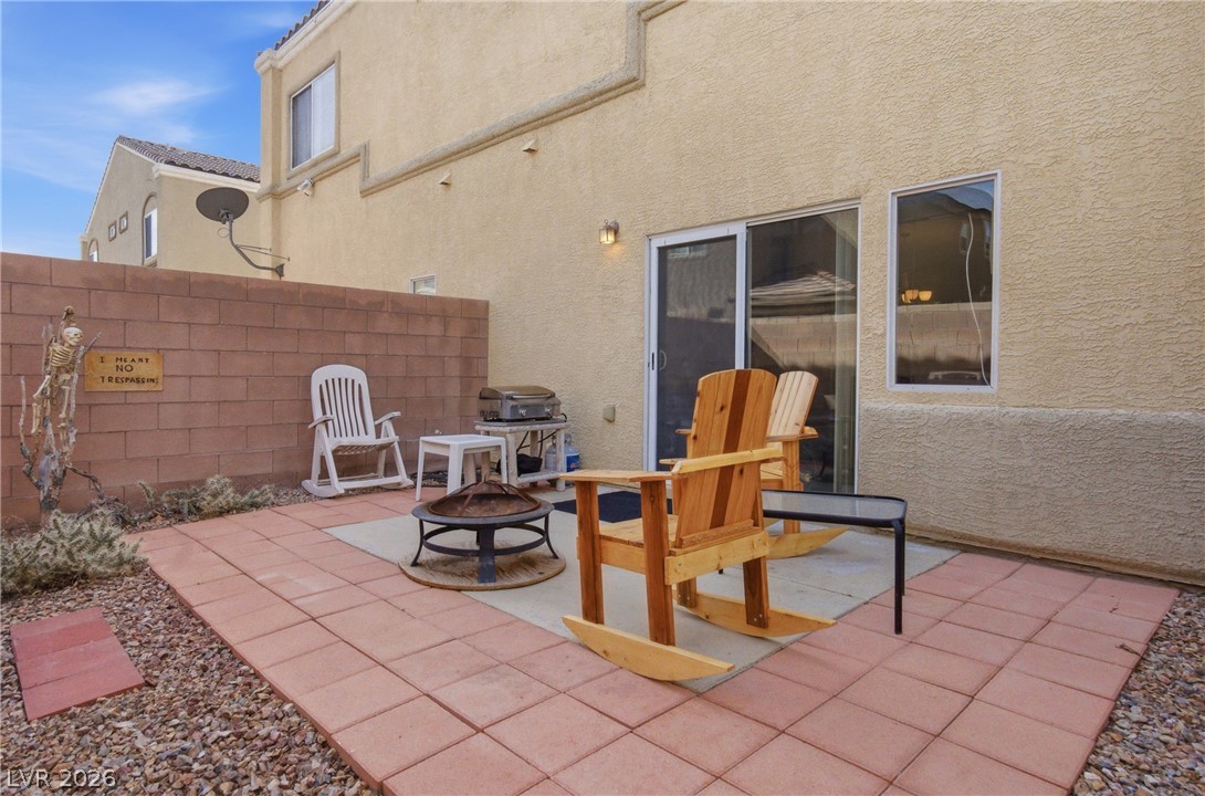 6316 Snap Ridge Street, Unit 101 North Las Vegas, NV 89081 - Photo 11 of 41 Finished backyard perfect for seating and grilling, complemented by decorative rock landscaping and mature palm accents.
