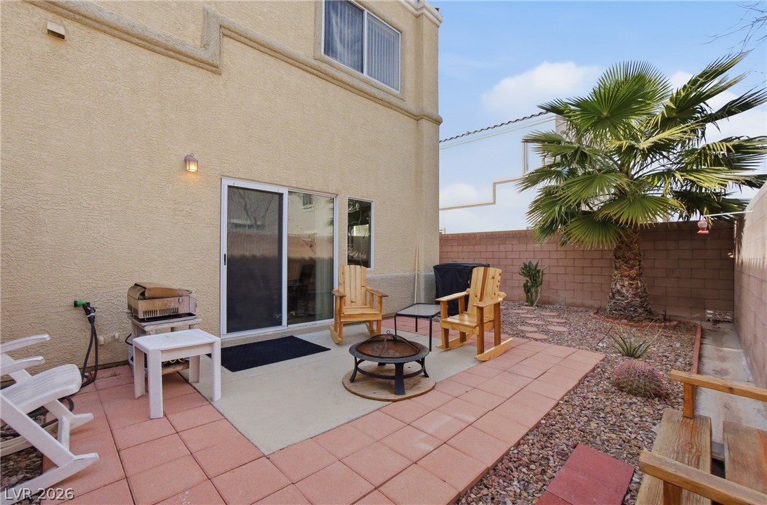 6316 Snap Ridge Street, Unit 101 North Las Vegas, NV 89081 - Photo 12 of 41 Finished backyard perfect for seating and grilling, complemented by decorative rock landscaping and mature palm accents.