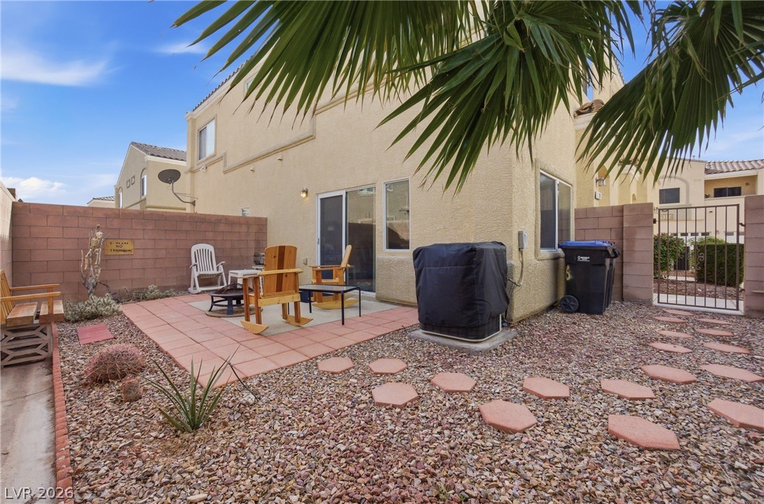 6316 Snap Ridge Street, Unit 101 North Las Vegas, NV 89081 - Photo 13 of 41 Finished backyard perfect for seating and grilling, complemented by decorative rock landscaping and mature palm accents.