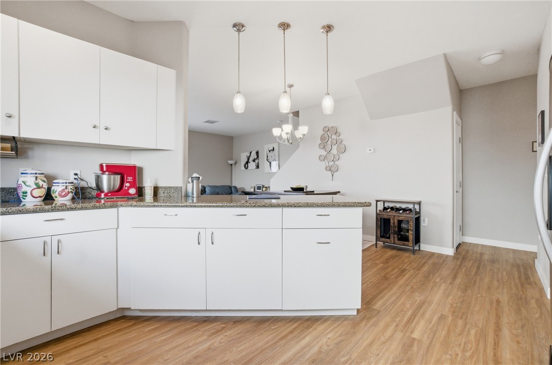 6316 Snap Ridge Street, Unit 101 North Las Vegas, NV 89081 - Photo 4 of 41 Updated Kitchen featuring white cabinets, stainless steel appliances, pendant lighting