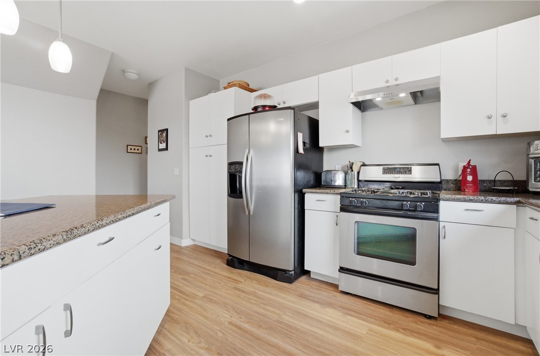 6316 Snap Ridge Street, Unit 101 North Las Vegas, NV 89081 - Photo 6 of 41 Updated Kitchen featuring white cabinets, stainless steel appliances, pendant lighting
