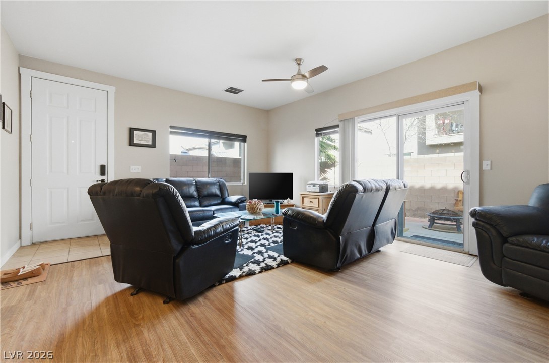 6316 Snap Ridge Street, Unit 101 North Las Vegas, NV 89081 - Photo 7 of 41 Spacious and well-lit, the living room provides direct access to the private backyard through a large sliding glass door. A functional layout allows for flexible furniture arrangement and easy indoor-outdoor living.