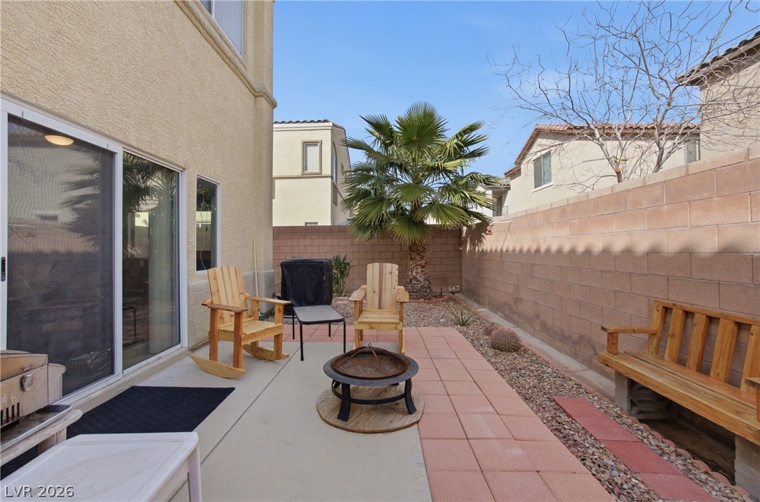 6316 Snap Ridge Street, Unit 101 North Las Vegas, NV 89081 - Photo 8 of 41 Finished backyard perfect for seating and grilling, complemented by decorative rock landscaping and mature palm accents.