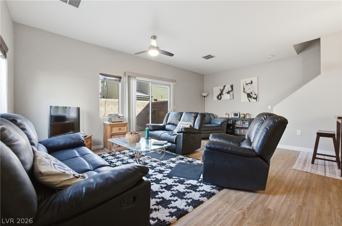 6316 Snap Ridge Street, Unit 101 North Las Vegas, NV 89081 - Photo 9 of 41 This inviting living area has laminate wood flooring, a ceiling fan, and abundant natural light. Open-concept layout creates a comfortable space for relaxing or gathering.