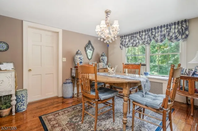 a view of a dining room with furniture a chandelier and wooden floor