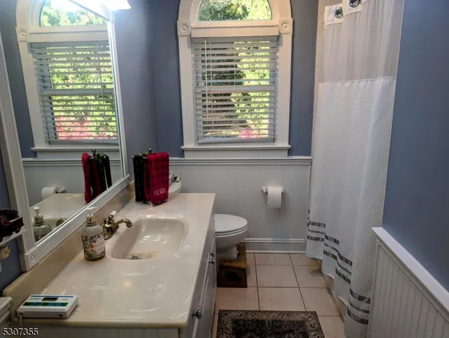 a bathroom with a granite countertop sink a toilet and tub